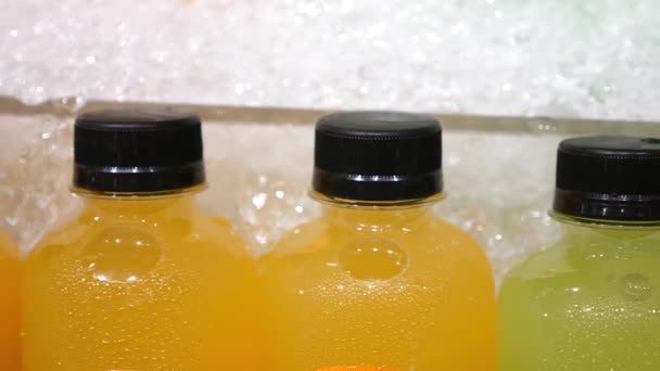 Közelkép a frissen facsart gyümölcslé műanyag palackokban a szupermarketben - Felvétel, videó