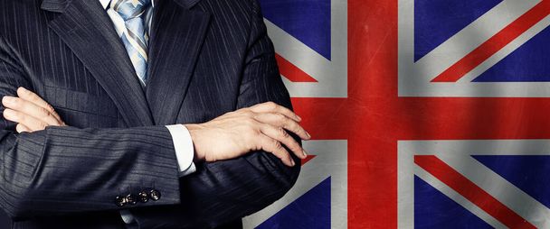 Businessman in a suit with his hands arms crossed on flag background - Photo, Image