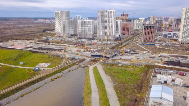 Ekaterinburg, Rusia. La construcción de un puente sobre el río. Nueva área de construcción - Akademicheskiy (Académico), Vista aérea   - Foto, imagen