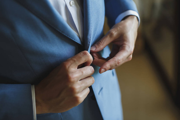 Man in the blue suit zips up the button on his jacket. - Foto, Imagem