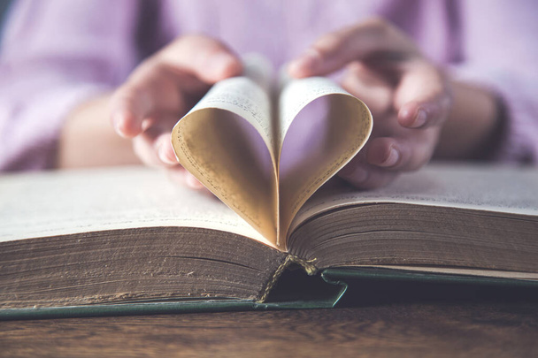 vrouw hand hart op boek papier - Foto, afbeelding
