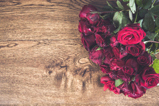 bouquet of red roses on wooden desk - Fotoğraf, Görsel