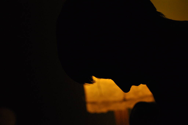 Σάντοου, σκιαγραφεί το πρόσωπο μιας γυναίκας σε ένα φως νύχτας. Συγκεντρώσου και σκέψου. Συγκέντρωση - Φωτογραφία, εικόνα
