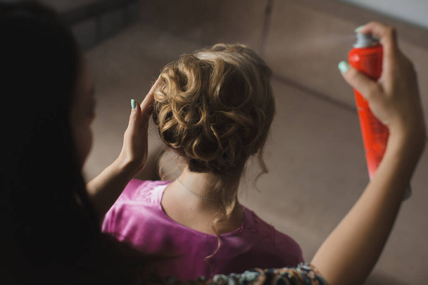 Master stylist makes the bride wedding hairstyle using spray lacquer fixing. - 写真・画像