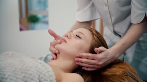 Massaggio - maestro di massaggio impastando zigomi di una giovane donna
 - Filmati, video