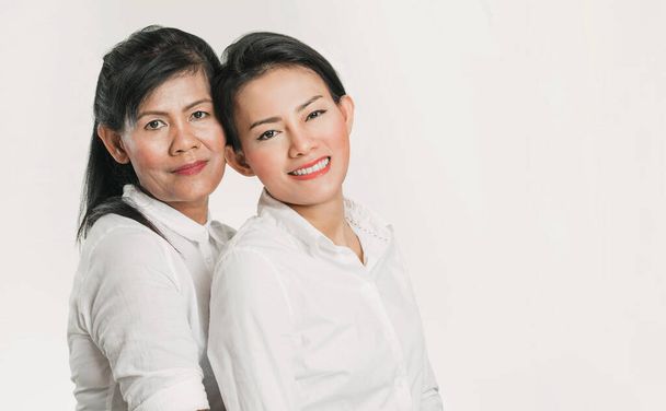 The happiness of an Asian mother whose daughter is hugging her on a white background - Foto, Imagem