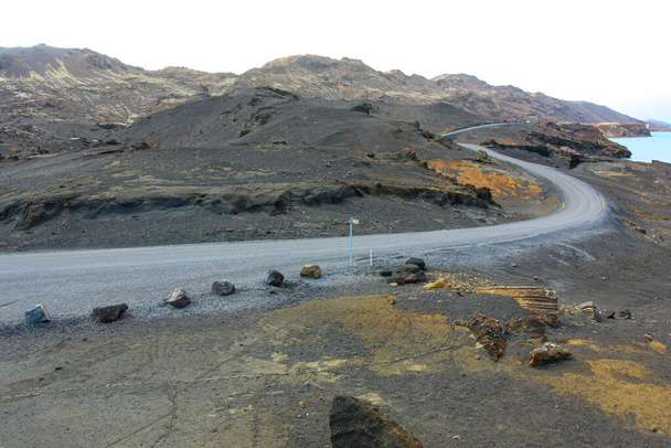 Carretera curva entre campos de lava. Camino al campo a ninguna parte
 - Foto, Imagen