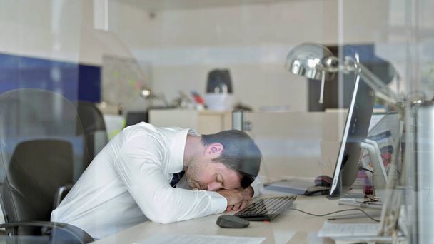 schläfriger Geschäftsmann mittleren Alters beim Mittagsschlaf während der Arbeit in seinem Büro - Foto, Bild