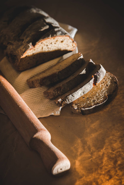 Chleb żytni w plasterkach, gotowany z orzechami i płatkami zbożowymi wewnątrz na stole z bliska - Zdjęcie, obraz