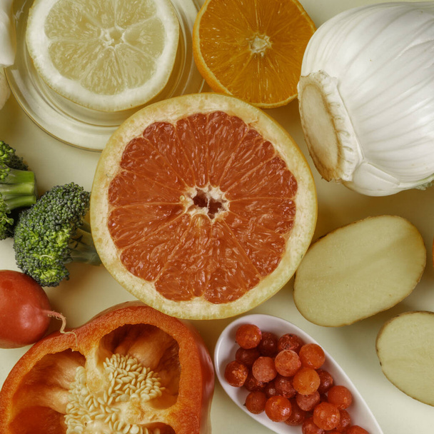 Egészséges táplálkozás, C-vitaminban gazdag természetes termékek, friss antioxidáns források, tiszta ételek színes választék, mint a grapefruit, citrom, narancs, paprika szeletek, édeskömény, burgonya, áfonya, brokkoli, közelkép - Fotó, kép