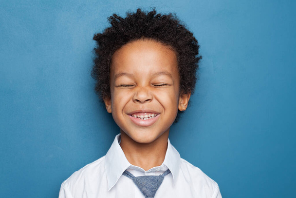 Laughing black kid on blue background - Foto, afbeelding