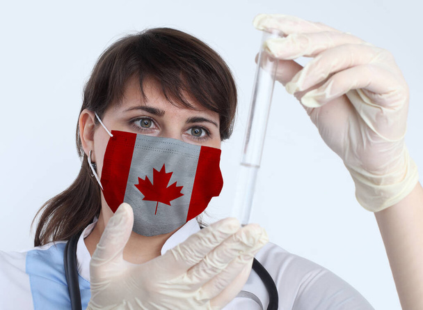Επιστήμονας γυναίκα και μάσκα με σημαία Καναδά. Έρευνα ιών σε εργαστήρια για την πρόληψη πανδημίας στον Καναδά - Φωτογραφία, εικόνα