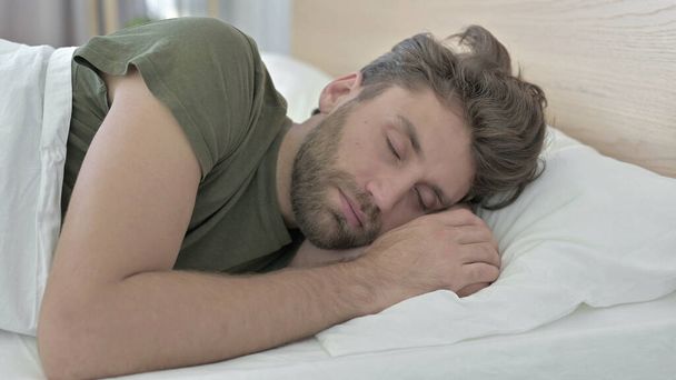 Primer plano de hombre joven que tiene comodidad durmiendo en la cama
 - Foto, imagen
