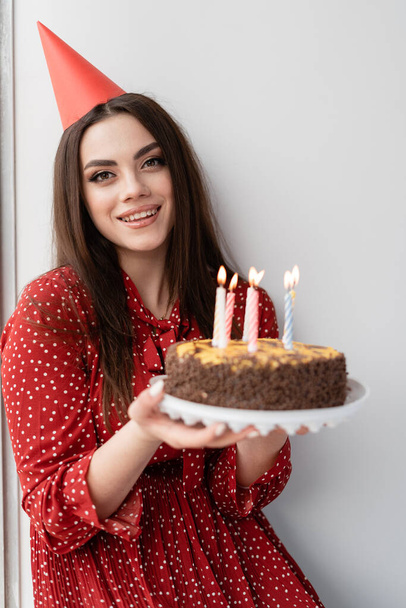 young beautiful woman on a white background. Tasty cake for the holiday. Birthday candles, make the most cherished wish - Valokuva, kuva