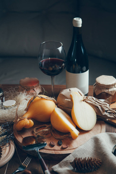 Composition of cheese with wine and honey. Caciocavallo cheese on a wooden Board.  - Valokuva, kuva