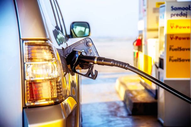 Benzin in ein Auto an einer Tankstelle pumpen. Verkehrskonzept - Foto, Bild