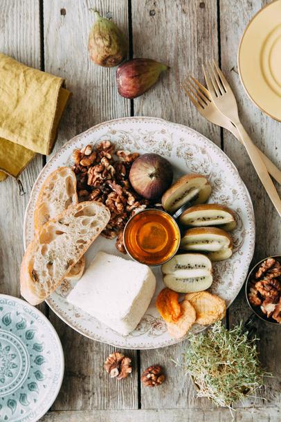 Flatley cheese plate with figs. Snacks for the company. Set of cheeses on a plate with honey and nuts.  - Photo, Image