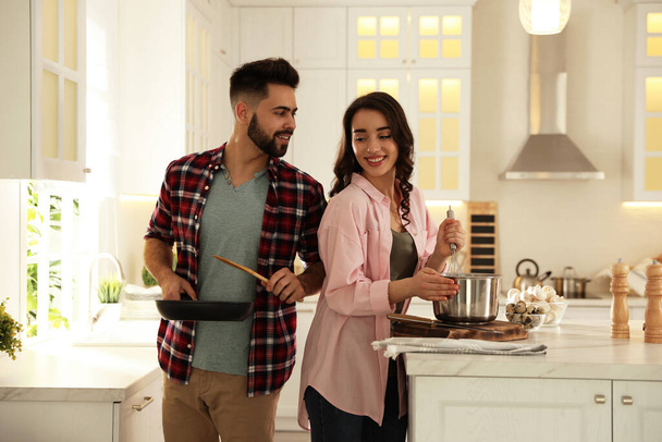 Lovely young couple cooking together in kitchen - Photo, image