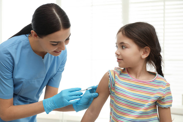 Doctor vaccinating little child in modern clinic - Fotoğraf, Görsel