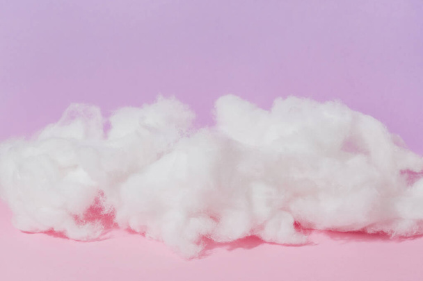 Zachte wolk van katoenen wol op een roze achtergrond - Foto, afbeelding