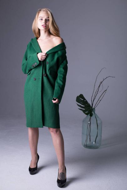 Gorgeous stylish blonde model posing in long luxurious green trench coat - Foto, Imagem