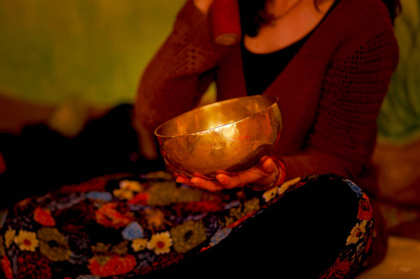 Spiritueel meisje ondergedompeld in meditatieve geluiden van tibetiaanse kom - Foto, afbeelding