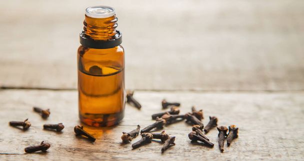 Clove essential oil in a small bottle. Selective focus. nature. - Photo, Image
