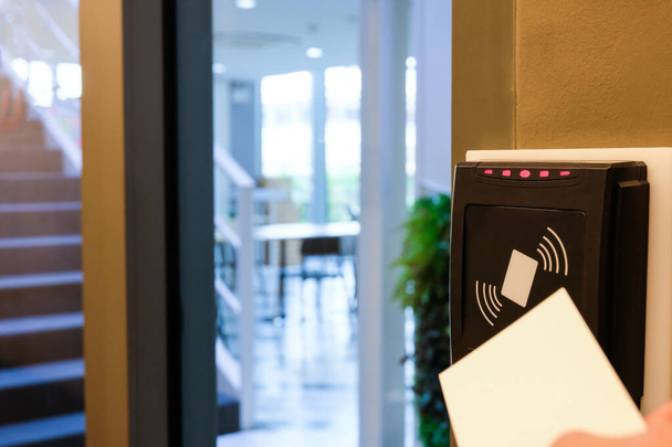 Muži se natahují, aby použili RFID kartu pro přístup do kancelářské budovy a pracovního prostoru. V zabezpečení budovy pouze pro autorizovanou osobu - Fotografie, Obrázek