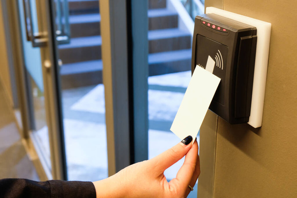 Kobiety sięgają po kartę RFID, aby uzyskać dostęp do powierzchni biurowej i miejsca pracy. W ochronie budynku tylko dla upoważnionej osoby - Zdjęcie, obraz