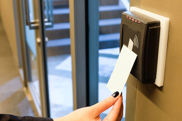 Γυναίκες χέρι φθάνοντας να χρησιμοποιήσετε RFID κάρτα-κλειδί για την πρόσβαση στο χώρο του κτιρίου γραφείων και του χώρου εργασίας. Στην ασφάλεια κτιρίου μόνο για εξουσιοδοτημένο πρόσωπο - Φωτογραφία, εικόνα