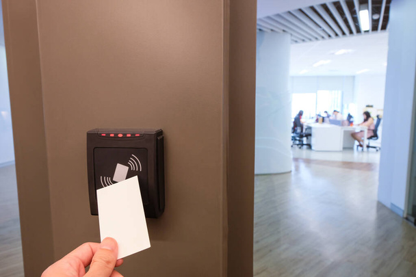 Mężczyźni sięgają po kartę RFID, aby uzyskać dostęp do powierzchni biurowej i miejsca pracy. W ochronie budynku tylko dla upoważnionej osoby - Zdjęcie, obraz