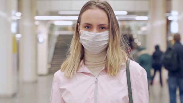 Γυναίκα σε προστατευτική αποστειρωμένη ιατρική μάσκα προσώπου κοιτάζοντας κάμερα στο σταθμό του μετρό, ιός, πανδημία έννοια coronavirus - Πλάνα, βίντεο