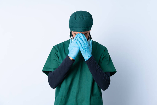 Chirurgo in uniforme verde su sfondo isolato con espressione stanca e malata
 - Foto, immagini