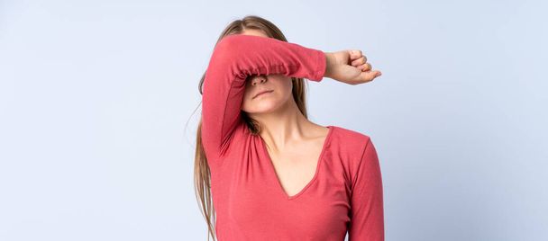 Teenager Ukrainian girl isolated on blue background covering eyes by hands - Photo, Image