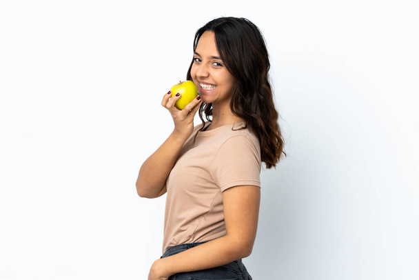 Young woman over isolated white background eating an apple - Photo, Image