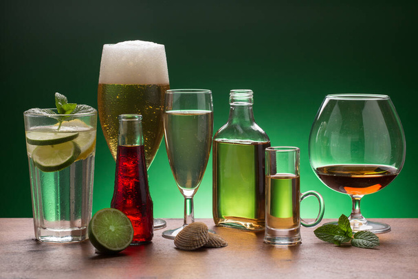variety of beverages (mojito, cognac, whiskey) on green background - Photo, Image
