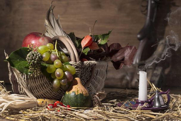 Composição de outono pitoresca com cesta, frutas, abóbora, vinho e copo de vinho, com feno no fundo de madeira velha
 - Foto, Imagem