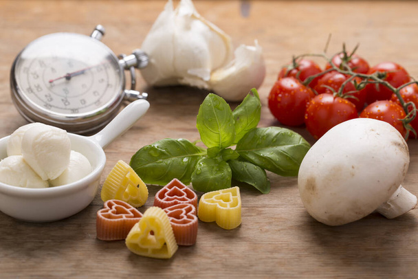 Italian food still life with pasta, tomatoes, mushroom and basil - Photo, Image