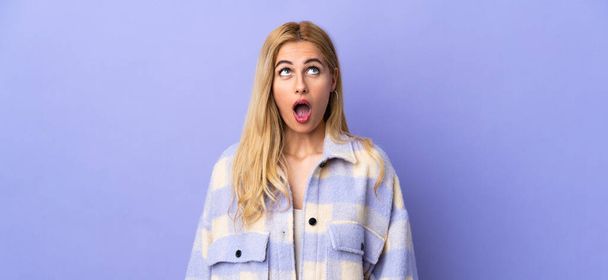 Young Uruguayan blonde woman over isolated background looking up and with surprised expression - Фото, зображення