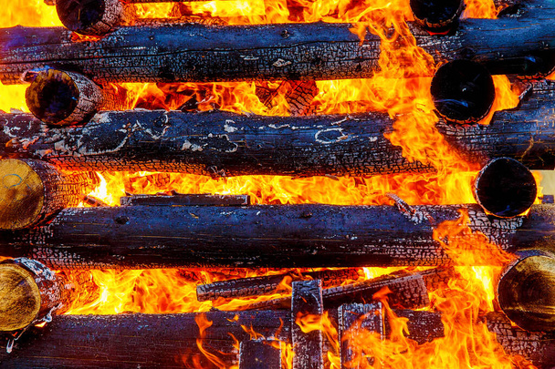 schöne Struktur aus brennenden Baumstämmen und Flammen des großen Feuers - Foto, Bild