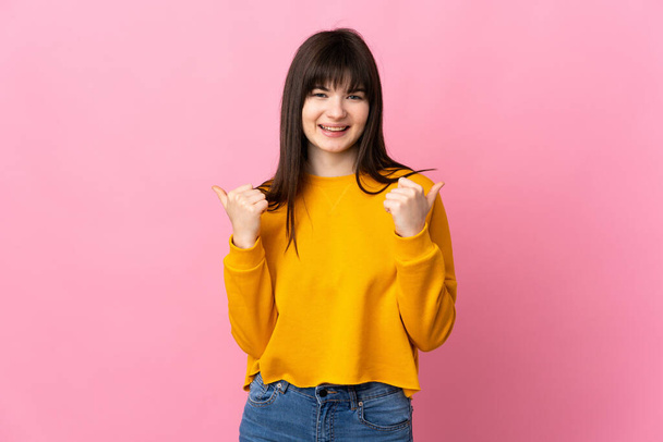 Young Ukrainian woman isolated on pink background with thumbs up gesture and smiling - Photo, Image