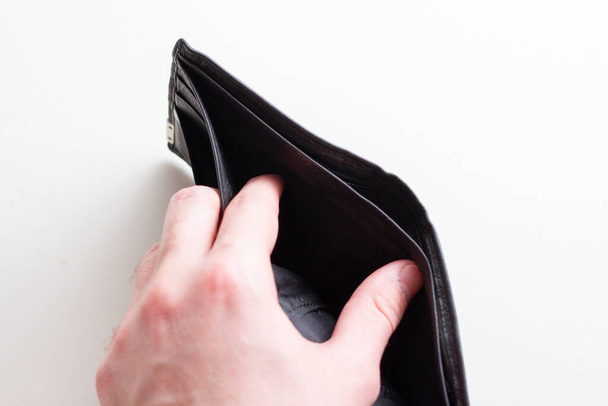 Man hand open een lege portemonnee op witte achtergrond - Foto, afbeelding