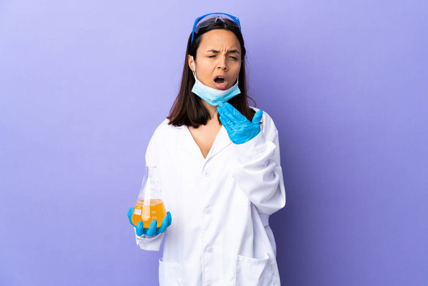 Scientist woman investigating a vaccine to cure coronavirus disease yawning and covering wide open mouth with hand - Photo, Image
