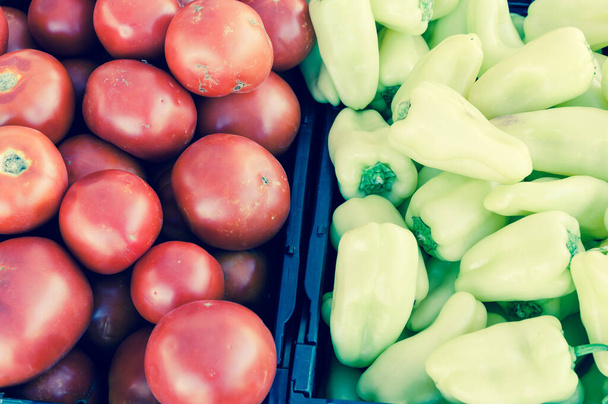 ジャラペノと赤いトマトは、アメリカのワシントンのファーマーズマーケットで生産されている黒いプラスチック食品に使われています。地元の農場からのサルサフルーツ。トップ表示フルフレーム背景. - 写真・画像
