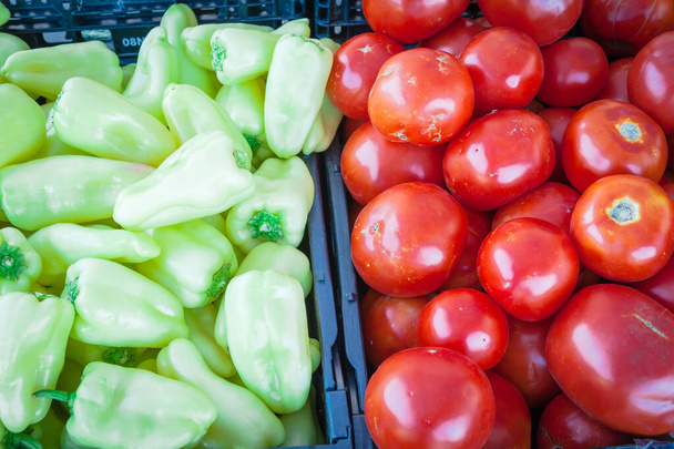 Jalapeño y tomates rojos en caja de plástico negro en el mercado de agricultores en Washington, Estados Unidos. Frutas de salsa de la granja local. Vista superior de fondo de marco completo
. - Foto, imagen
