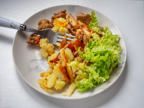 Snídaně se smaženým kuřetem a bramborami se skluzavkou jemně nasekaného pekingského zelí na šedém talíři zblízka - Fotografie, Obrázek