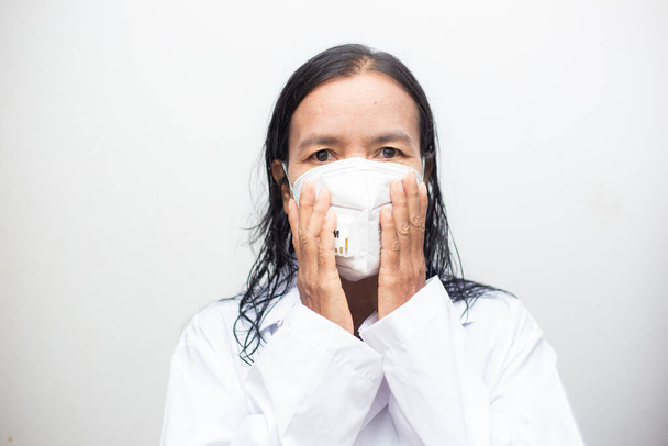 Ηλικιωμένες Ασιάτισσες που φορούν μάσκες KN95 καλύπτοντας το στόμα και τη μύτη τους αποτρέποντας τον κορωναϊό και το pm 2.5 σκόνη σε λευκό φόντο. Ανώτερες έννοιες υγείας - Φωτογραφία, εικόνα