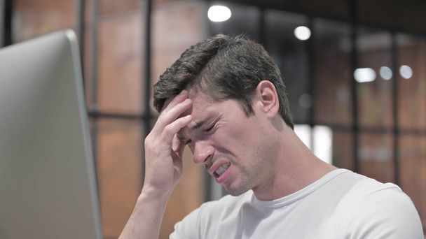 Close Up of Young Man com dor de cabeça no trabalho
 - Foto, Imagem