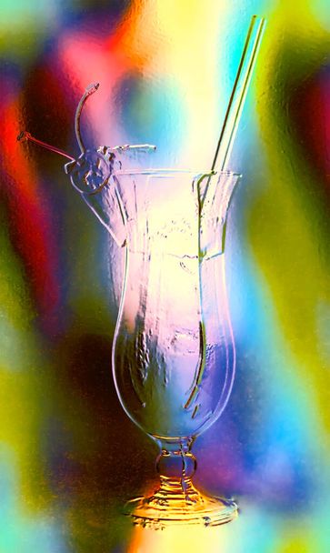 ガラス効果で抽象的なぼやけたカラフルな背景にストロー付きロングドリンクグラス - 写真・画像