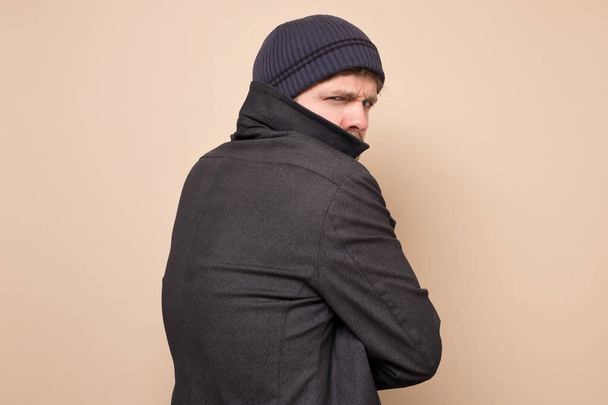Young caucasian speculator man gangster or bandit looking angry at camera closing his coat. Studio shot - Fotó, kép